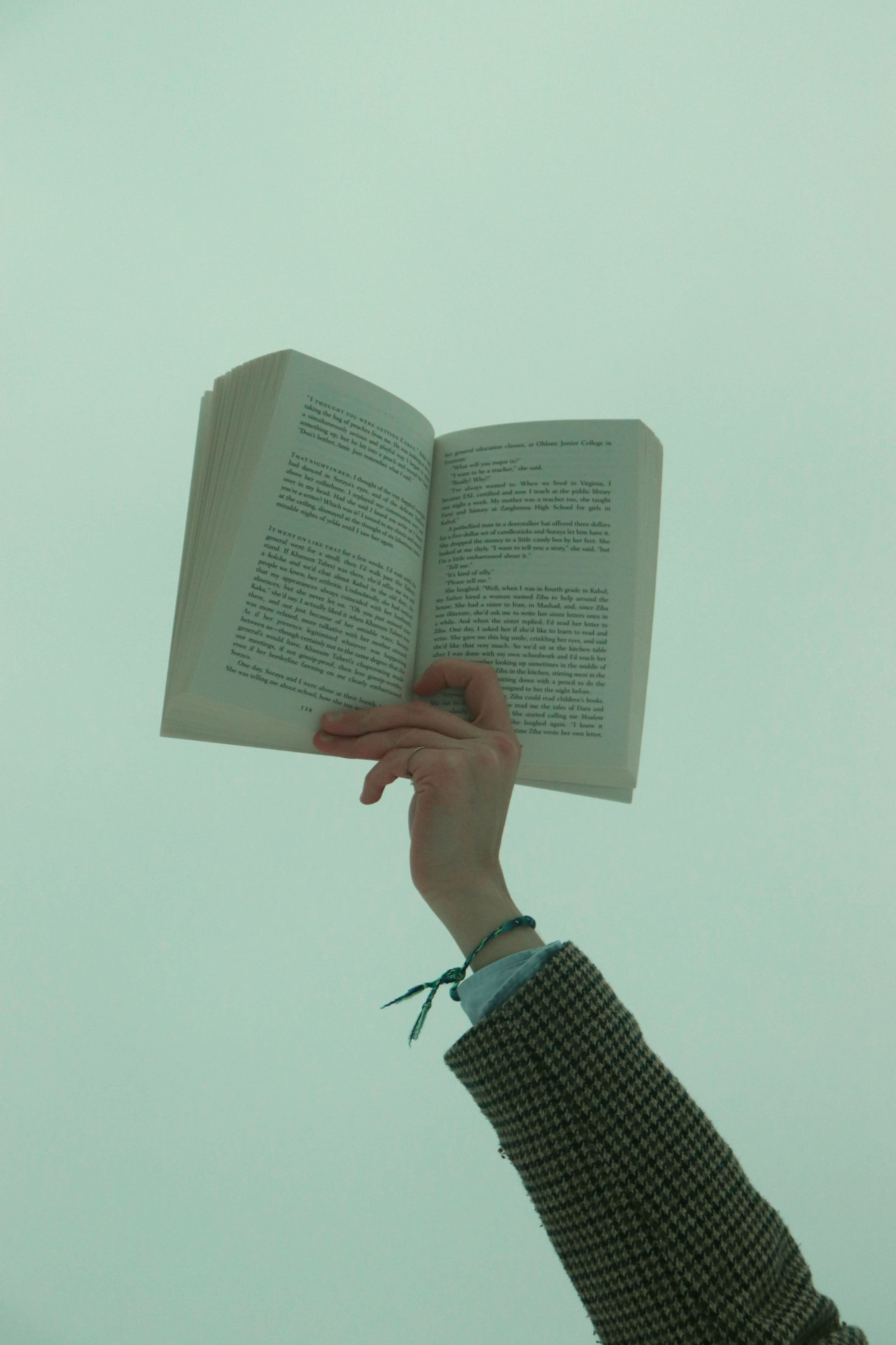 Hand hält Buch vor einen grünen Hintergrund. Foto: rüveyda/Pexels – rüveyda/Pexels